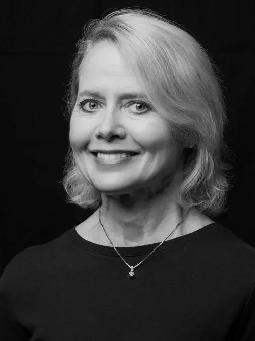 A black and white photo of a woman smiling.