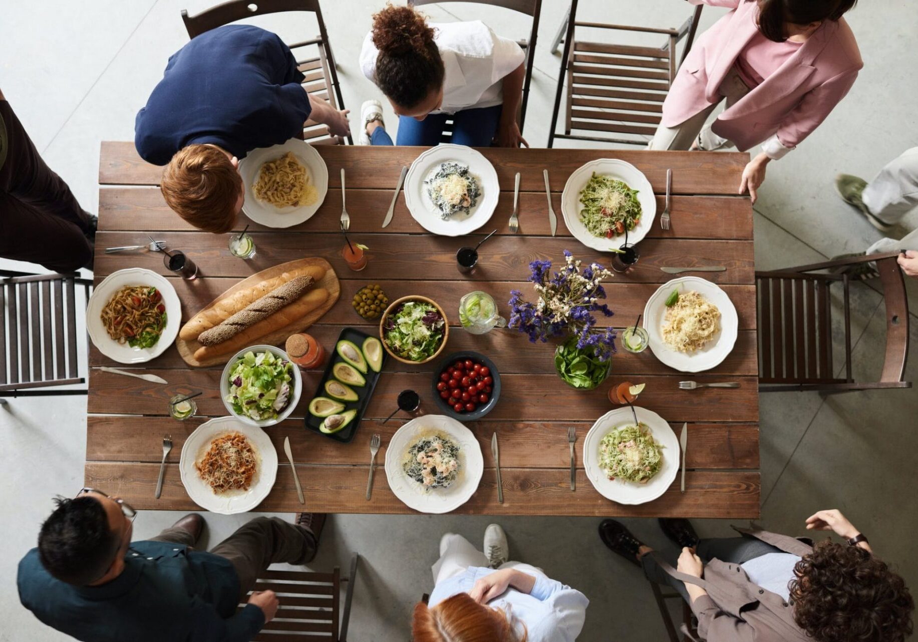 A group of people sitting around a table with food.